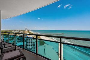 einen Balkon mit Blick auf den Strand und das Meer in der Unterkunft Glass Wrapped Around Corner Unit Unbeatable View in Myrtle Beach + 31 Fotos
