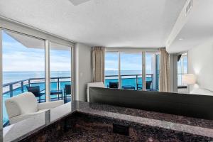 ein Wohnzimmer mit Blick auf das Meer in der Unterkunft Glass Wrapped Around Corner Unit Unbeatable View in Myrtle Beach