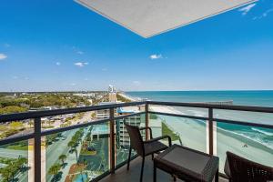 einen Balkon mit Blick auf den Strand und das Meer in der Unterkunft Glass Wrapped Around Corner Unit Unbeatable View in Myrtle Beach