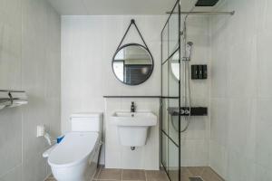 a bathroom with a toilet and a sink and a mirror at 오션스테이 호텔 in Busan