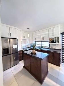 a large kitchen with stainless steel appliances and a island at Casona Álamo in La Coyotera