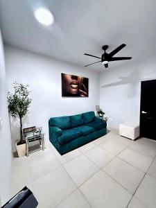 a living room with a green couch and a ceiling fan at Casona Álamo in La Coyotera