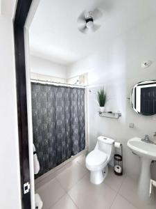 a white bathroom with a toilet and a sink at Casona Álamo in La Coyotera