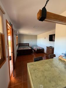 圣胡利安港Cabañas La Sonrisa的客厅里有一张床、一张桌子和几把椅子。