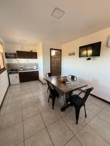 圣胡利安港Cabañas La Sonrisa的厨房兼餐厅，配有桌椅