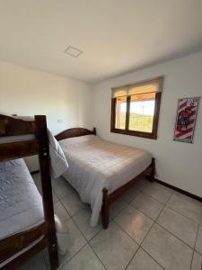 圣胡利安港Cabañas La Sonrisa的一间卧室，里面有一张床和一扇窗户。