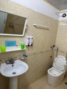 a bathroom with a sink and a toilet and a mirror at Nhà Nghỉ Đông Phương in Lạng Sơn +18 photos