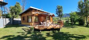 una piccola casa in legno con portico in cortile di Casa Radal a Lago Puelo
