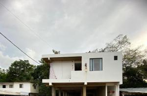 a white house with trees in the background at Rosablanca RN in Guaduas