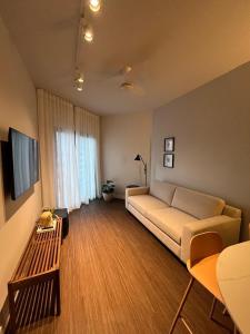 Summit Flat São José dos Campos في ساو جوزيه دوس كامبوس: غرفة معيشة بها أريكة وطاولة