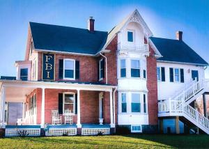 a large red brick house with a sign on it at Heartland suites in Gettysburg
