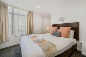 a bedroom with a large bed with two towels on it at The Alps Apartment in Queenstown