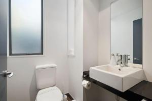a bathroom with a white toilet and a sink at The Alps Apartment in Queenstown +16 photos