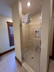 Heartland suites bed and breakfast في غيتسبرغ: دش مع باب زجاجي في الحمام