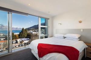 a bedroom with a large bed and a large window at Ballarat Bungalow in Queenstown