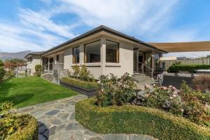 a home with a garden and a house at Botanical Bliss in Arrowtown