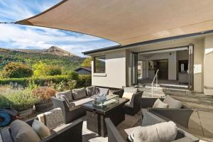 an outdoor living room with couches and a table at Botanical Bliss in Arrowtown