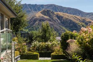 a house with a garden with mountains in the background at Botanical Bliss in Arrowtown +14 photos