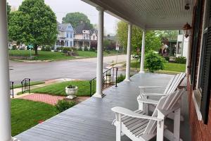 Heartland suites bed and breakfast في غيتسبرغ: شرفة بها كرسيان أبيضان وشارع
