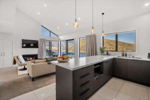 a kitchen and living room with a couch and a fireplace at Bluewater Views in Queenstown