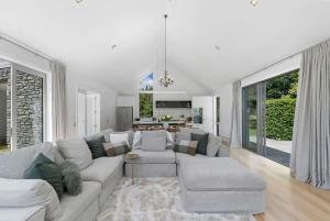 a white living room with a couch and a table at Glebe Arrowtown in Arrowtown