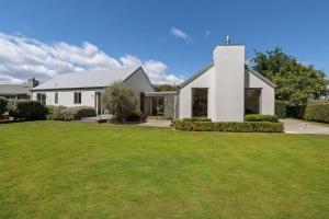 a white house with a green yard at Glebe Arrowtown in Arrowtown