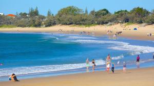 a group of people walking on a beach at Brisbane Road Apartments Mooloolaba in Mooloolaba