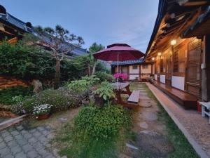 a patio with a table and an umbrella at Hanok Dream in Jeonju
