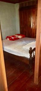 a bed with a red pillow on top of it at GIẤY BẢN KÍNH THÀNH - Homestay! in Cao Bằng