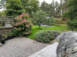 Un jardín con una pasarela de madera y un banco. en 6 person holiday home in STRÖMSTAD, en Strömstad