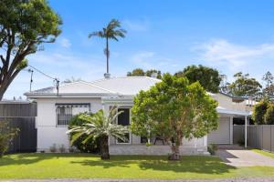 ein weißes Haus mit Bäumen im Vorgarten in der Unterkunft Nans at Northy - modern river cottage in North Haven