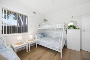 ein Schlafzimmer mit einem Etagenbett und einem Sofa in der Unterkunft Nans at Northy - modern river cottage in North Haven