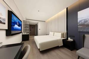 a bedroom with a white bed and a flat screen tv at Atour Hotel Shanghai Songjiang G60 Dongjing in Shanghai +45 photos