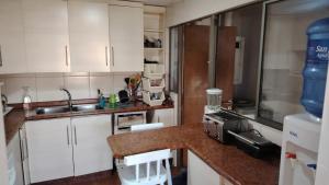 a kitchen with white cabinets and a counter top at Mi casa es tu casa in La Serena