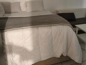 a bed with a white comforter on it at RELAX Privacy in Sarcelles