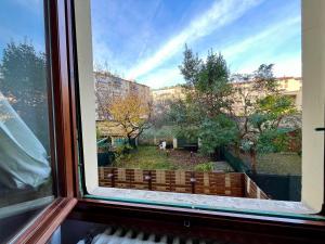 a window with a view of a garden at Florence Lungarno Apartment in Florence