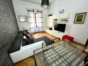 a living room with a white couch and a glass table at Florence Lungarno Apartment in Florence