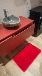 eine rote Theke mit Spülbecken und rotem Teppich in der Unterkunft Casa Giulia in Triest