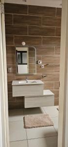 un baño con lavabo y espejo en La Casa Modesta, en Matola