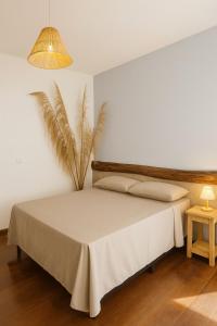 a bedroom with a large bed and a lamp at Studio Privativo a 3 min Centro c Ar Condicionado in Uberlândia