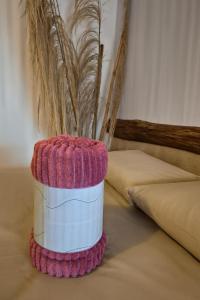 a pink and white container sitting on top of a bed at Studio Privativo a 3 min Centro c Ar Condicionado in Uberlândia