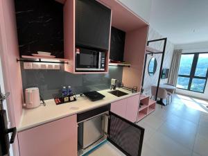 a kitchen with pink walls and a counter top at Paxtonz Premium Studio-IKEA,One Utama,Hextar World-Damansara KL in Petaling Jaya