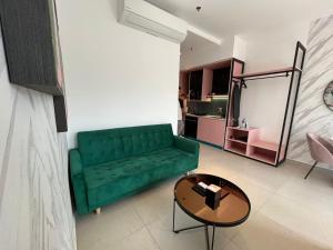 a living room with a green couch and a table at Paxtonz Premium Studio-IKEA,One Utama,Hextar World-Damansara KL in Petaling Jaya