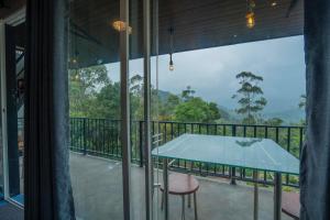 a balcony with a table and a view of the forest at Lavee Villa Ella in Ella