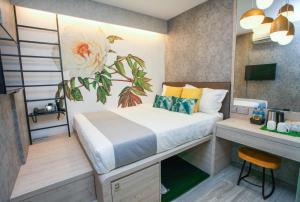 um pequeno quarto com uma cama e uma secretária em Champion Hotel City em Singapura