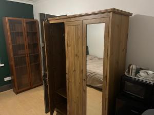 um quarto com um armário de madeira e uma cama em The Gables em Sandwich