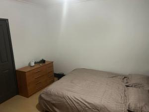 um quarto com uma cama e uma cómoda em madeira em The Gables em Sandwich