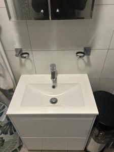 uma pia branca em um banheiro com espelho em The Gables em Sandwich