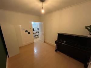 uma sala de estar com um piano e um corredor em The Gables em Sandwich