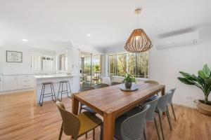 a kitchen and dining room with a wooden table and chairs at Spades - at Lighthouse Beach in Port Macquarie